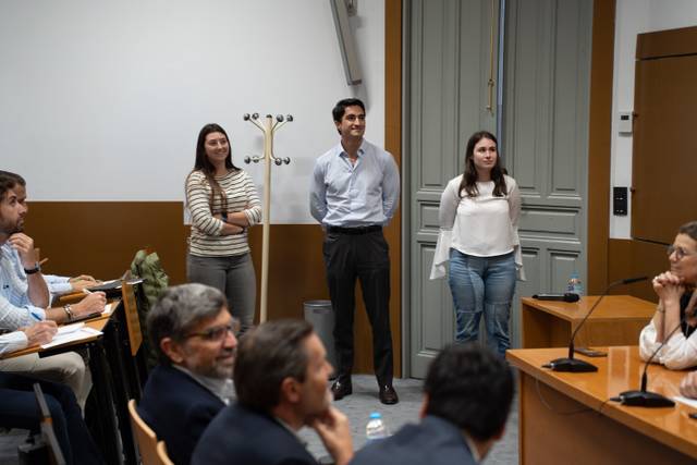 Un grupo de personas de pie frente a una audiencia en un evento o presentación.