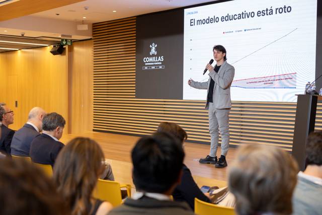 Un orador presenta un gráfico sobre el modelo educativo en un evento.