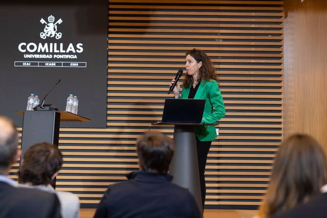 Una mujer da una presentación en un auditorio de la Universidad Pontificia Comillas.