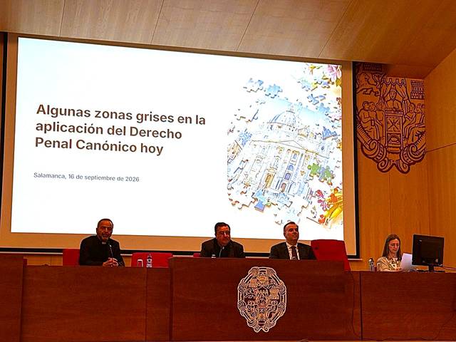 Una mesa de conferencias con varios ponentes discutiendo sobre el Derecho Penal Canónico en un evento académico.