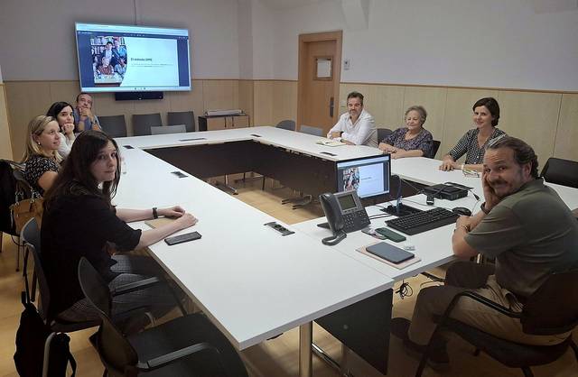 Un grupo de personas está reunido en una sala de conferencias, participando en una discusión o presentación.
