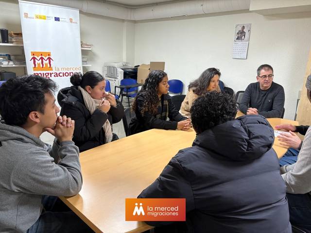 Un grupo de personas se reúne en una mesa en un ambiente de oficina.