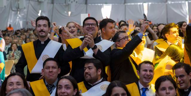 Un grupo de personas celebrando en una ceremonia, con sashes y sonrisas.