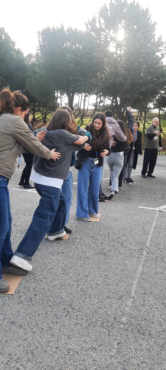 Un grupo de personas participa en una actividad grupal al aire libre.