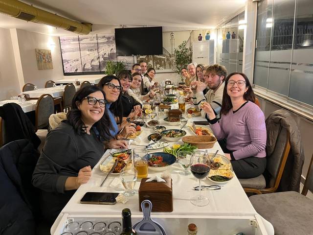 Un grupo de personas sonrientes disfrutando de una cena en un restaurante.