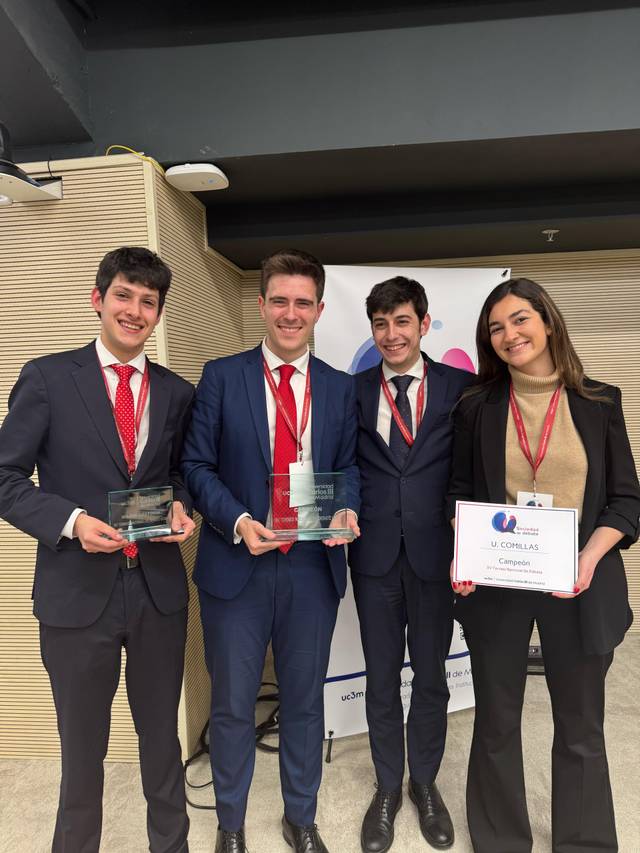 Un grupo de cuatro jóvenes posan juntos mostrando sus premios en un evento formal.