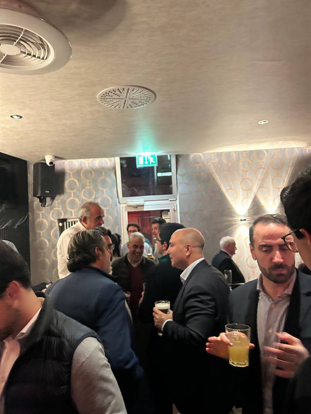 Un grupo de personas conversando y disfrutando en un bar.