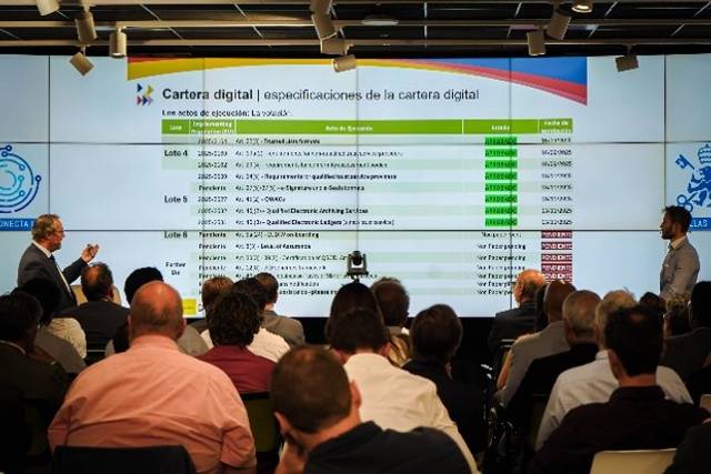 Una presentación sobre la cartera digital en un evento con público asistente.