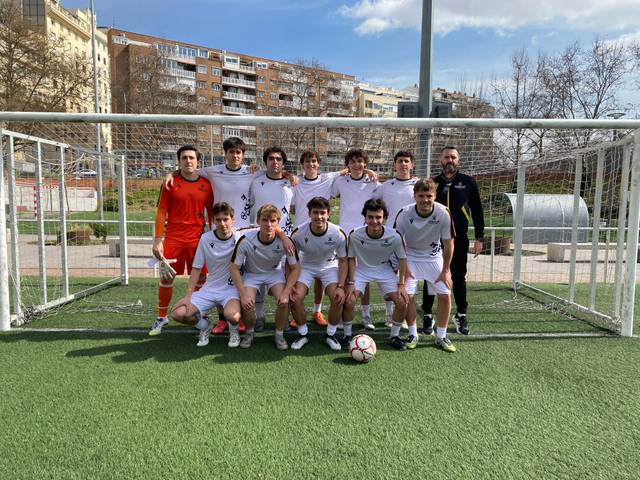 Un equipo de fútbol posando en el campo en un día soleado.