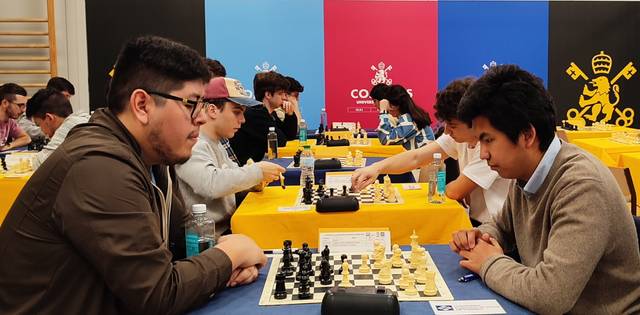 People playing chess at a tournament with focused expressions.