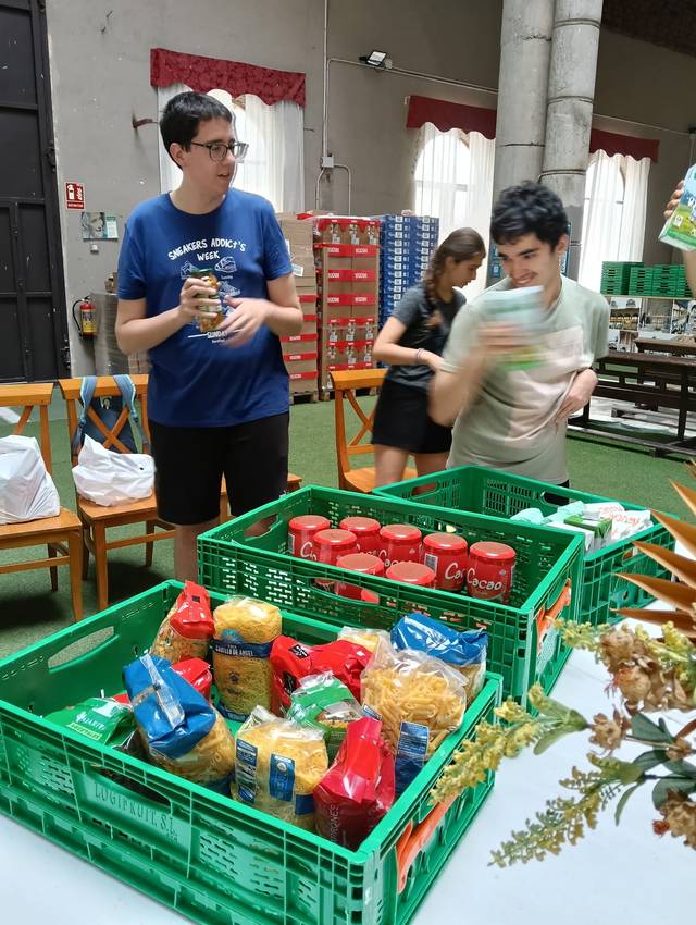 Un grupo de jóvenes organiza alimentos en una sala con estanterías.
