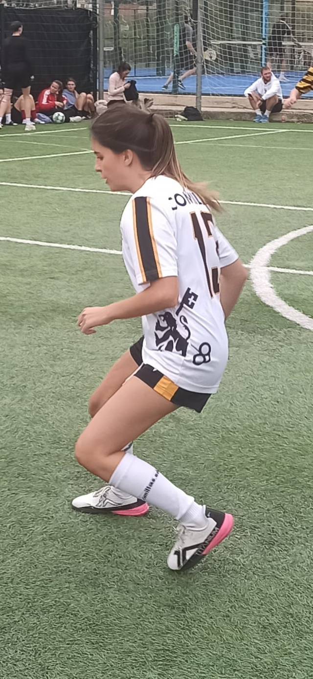 Una jugadora de fútbol en movimiento sobre el campo.