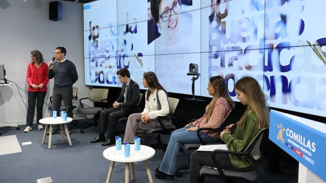 Un panel de discusión en un evento con varias personas en un escenario y una presentación en pantalla.