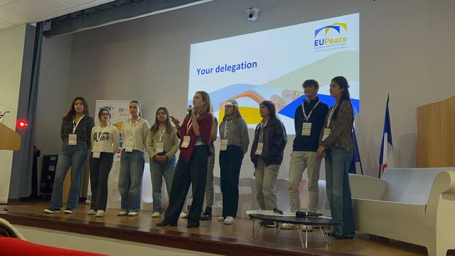 Un grupo de personas presentando en un evento sobre la paz en Europa.