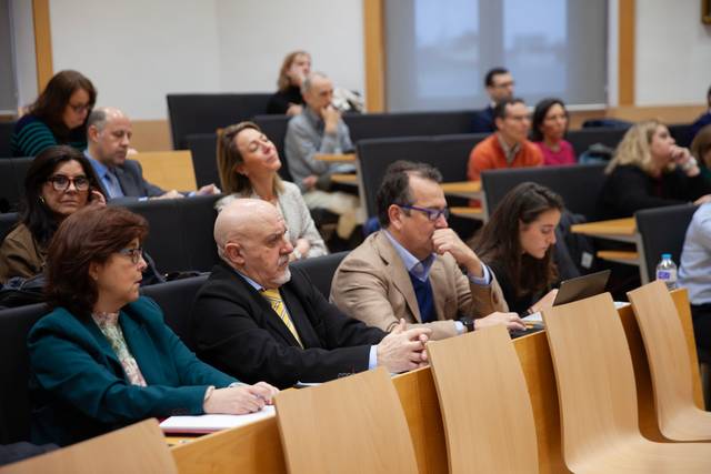 Una multitud de personas sentadas en un aula durante una presentación.