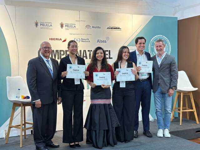 Un grupo de personas sonrientes sosteniendo certificados en un evento de premiación.