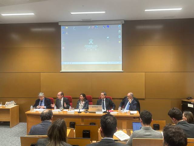 Una mesa redonda con varios ponentes en un auditorio universitario.