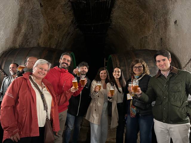 Un grupo de personas celebra con cervezas en un ambiente familiar y amigable.