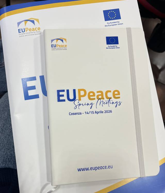 La imagen muestra un cuaderno y una carpeta relacionados con las reuniones de primavera de EUPeace en Cosenza en abril de 2026.