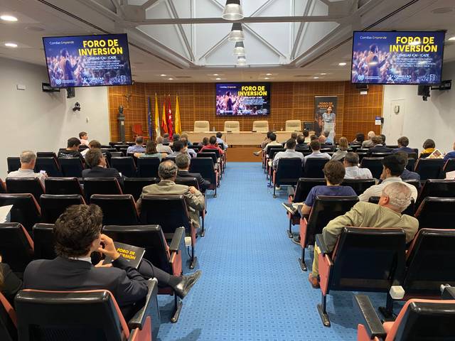 A conference room with attendees seated and listening to speakers at the front under a sign saying 'FORO DE INVERSION'.