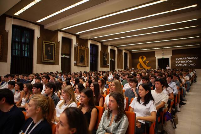 Una gran multitud de jóvenes prestando atención en un auditorio.