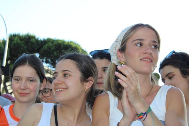 Un grupo de chicas sonrientes se encuentran en un evento al aire libre.