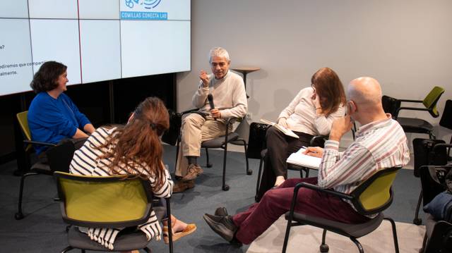 Un grupo de personas se reúne para discutir en un entorno académico.