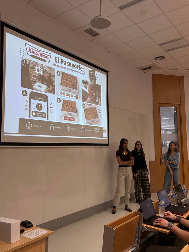 Una presentación grupal en un aula sobre un programa de Krispy Kreme llamado 'El Pasaporte'.