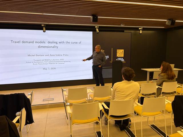 Un presentador habla sobre modelos de demanda de viajes en una sala de conferencias.