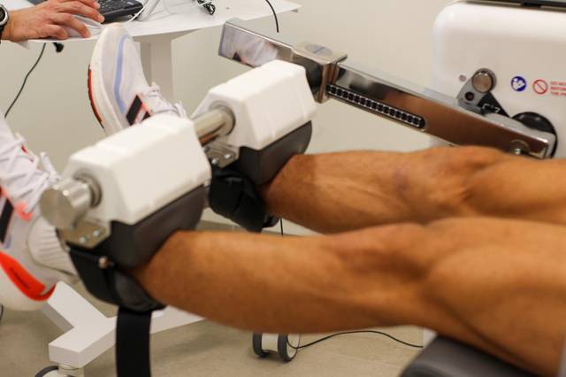 Una persona está utilizando una máquina de ejercicios para las piernas en un gimnasio.