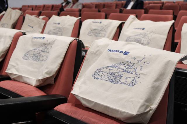 Sillas de teatro con bolsas de tela estampadas en un evento.
