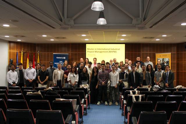 Un grupo de estudiantes y profesores posan juntos en un evento relacionado con un máster en gestión de proyectos industriales.