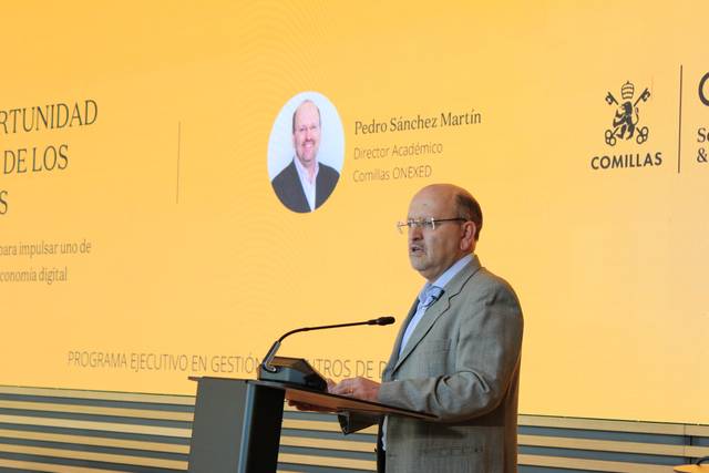 Un ponente habla en un evento sobre la economía digital en un escenario institucional.