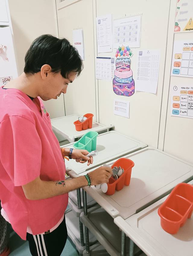 Una persona organiza utensilios en un entorno de cocina.