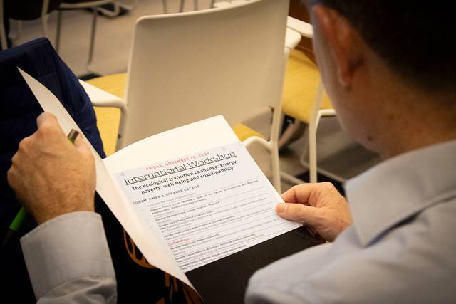 Un hombre leyendo un documento titulado 'International Mediation' en una sala con otras personas.