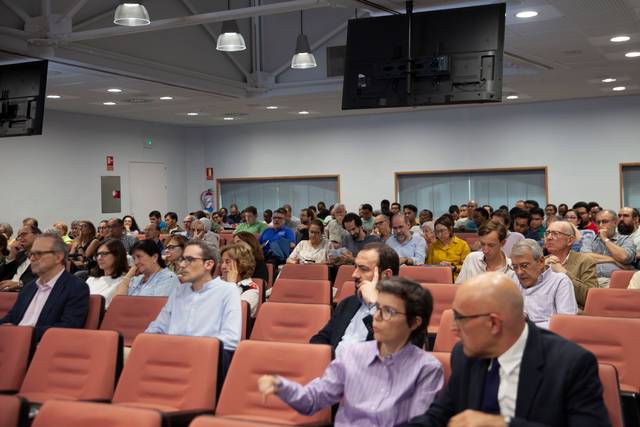 Una presentación frente a una gran audiencia en un salón de conferencias.