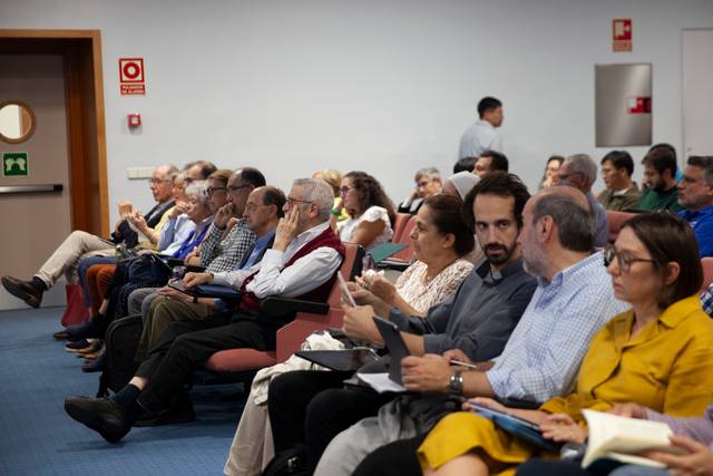 Un grupo de personas sentadas en un auditorio durante un evento.
