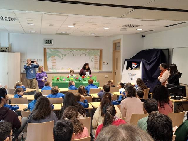 Un grupo de estudiantes observa una presentación en un aula escolar.
