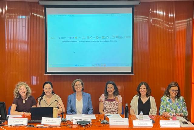 La imagen muestra a un grupo de seis mujeres sentadas alrededor de una mesa en un evento académico.