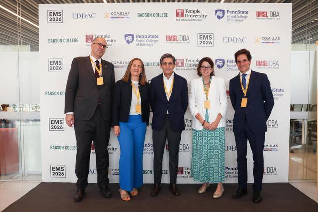 Grupo de personas posando en un evento académico con un fondo de logos de diferentes instituciones.