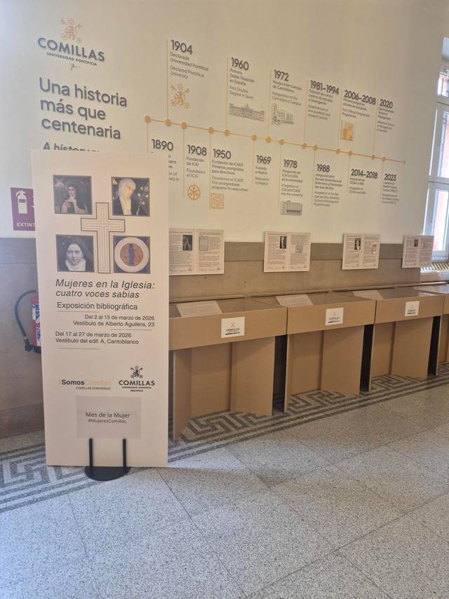Exposición sobre mujeres en la iglesia con un panel informativo y cajas vacías en un espacio público.
