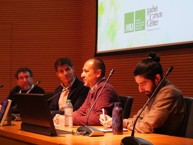 Un grupo de cuatro panelistas discutiendo en un evento en un auditorio.