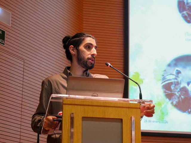 Un hombre habla frente a un micrófono en una presentación.