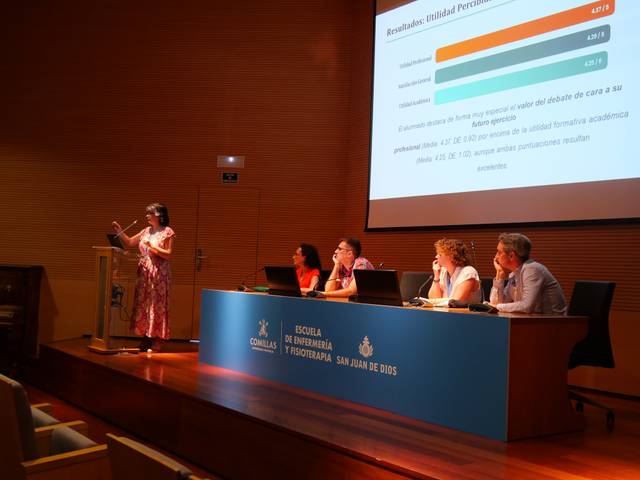 Una presentación en un aula con una oradora y un panel de expertos discutiendo resultados de un estudio.
