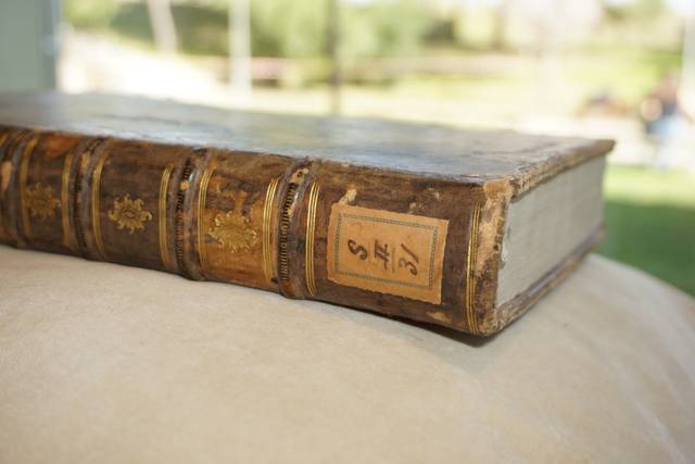 Un libro antiguo con encuadernación de cuero y decoración dorada.