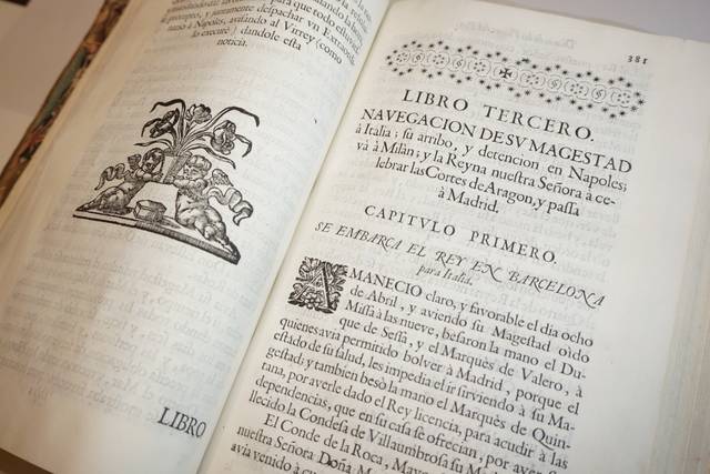 La imagen muestra un libro antiguo con un texto en castellano que trata sobre la navegación y la historia relacionada con la Monarquía Española.