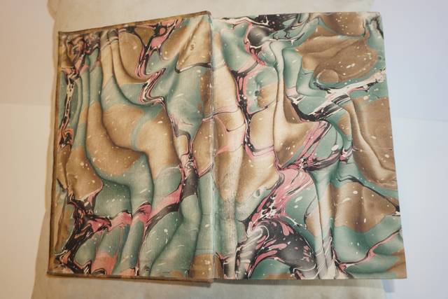 Una imagen que muestra un diseño abstracto en una superficie de color beige, azul y rosa con patrones fluidos.