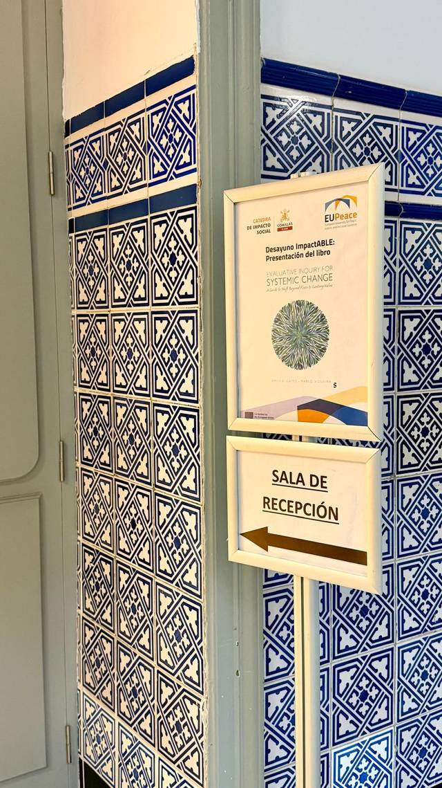 Una esquina de una pared decorada con azulejos y un cartel que indica la sala de recepción.