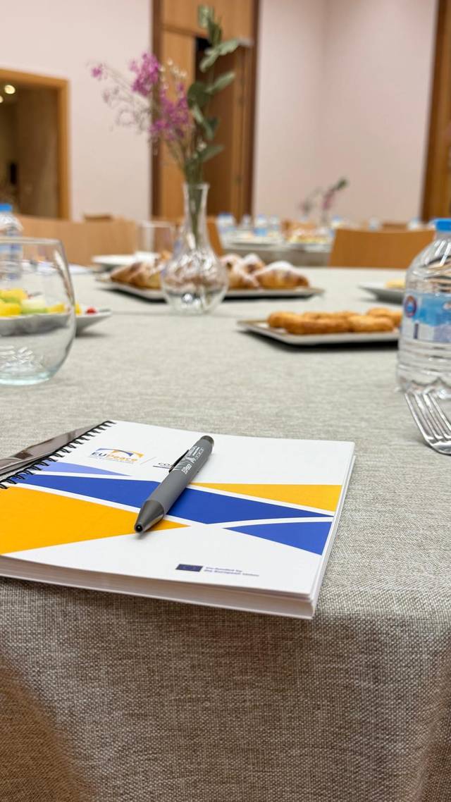 Una mesa de reunión con un cuaderno, un bolígrafo y varios platos de comida.
