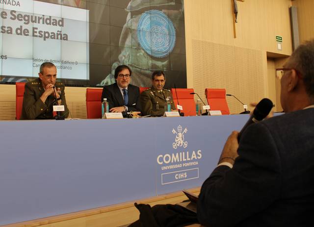 Un panel de discusión sobre la seguridad en España con varios ponentes en una universidad.